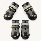 Complete set of four grey and black dog shoes featuring adjustable straps and yellow paw print embroidery on a white background.