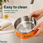 Running tap water rinsing clean the smooth stainless steel interior of a personalized orange pet food bowl.