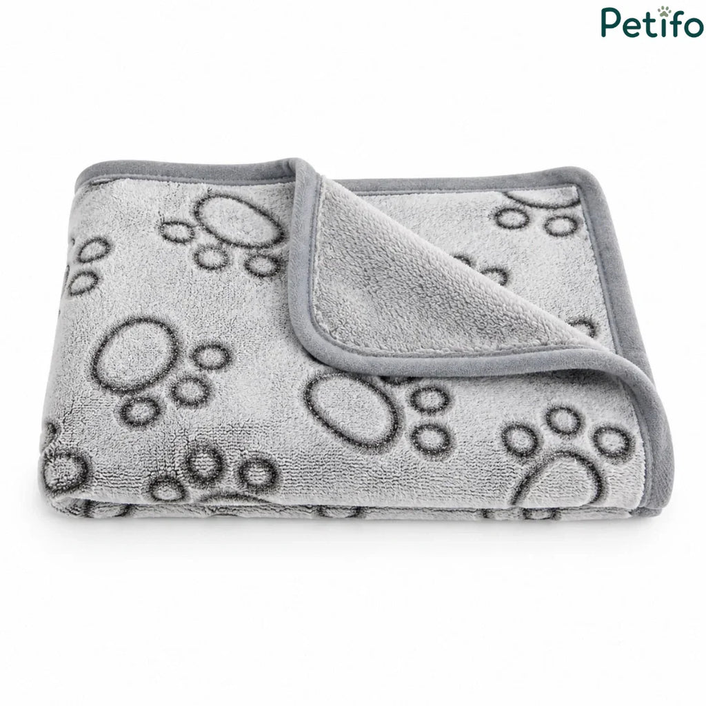 Neatly folded grey paw print pet blanket showcasing its premium fleece texture and stitched border.