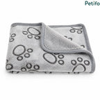 Neatly folded grey paw print pet blanket showcasing its premium fleece texture and stitched border.
