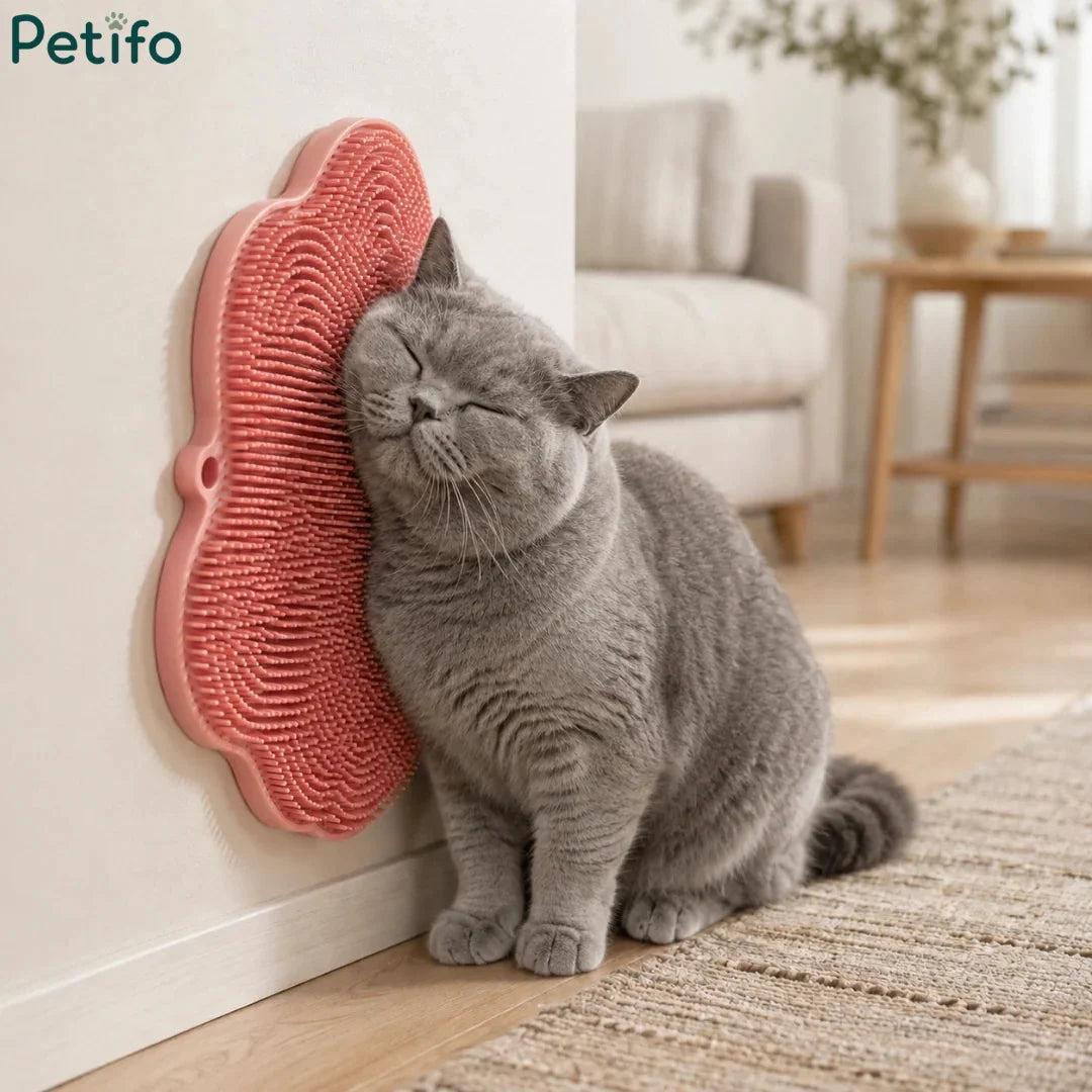 A gray cat blissfully rubbing its face against a pink cat self-groomer pad securely attached to a wall corner.