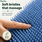 Close-up view of a finger pressing into the soft and gentle blue silicone bristles designed to massage sensitive cat skin.