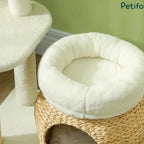 Close-up view of the cozy, thick-cushioned plush bed resting on top of the woven rattan cat basket hideaway.