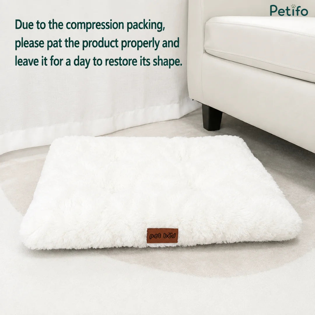 Fluffy white rectangular pet bed displayed on a carpeted floor with text regarding compression recovery.